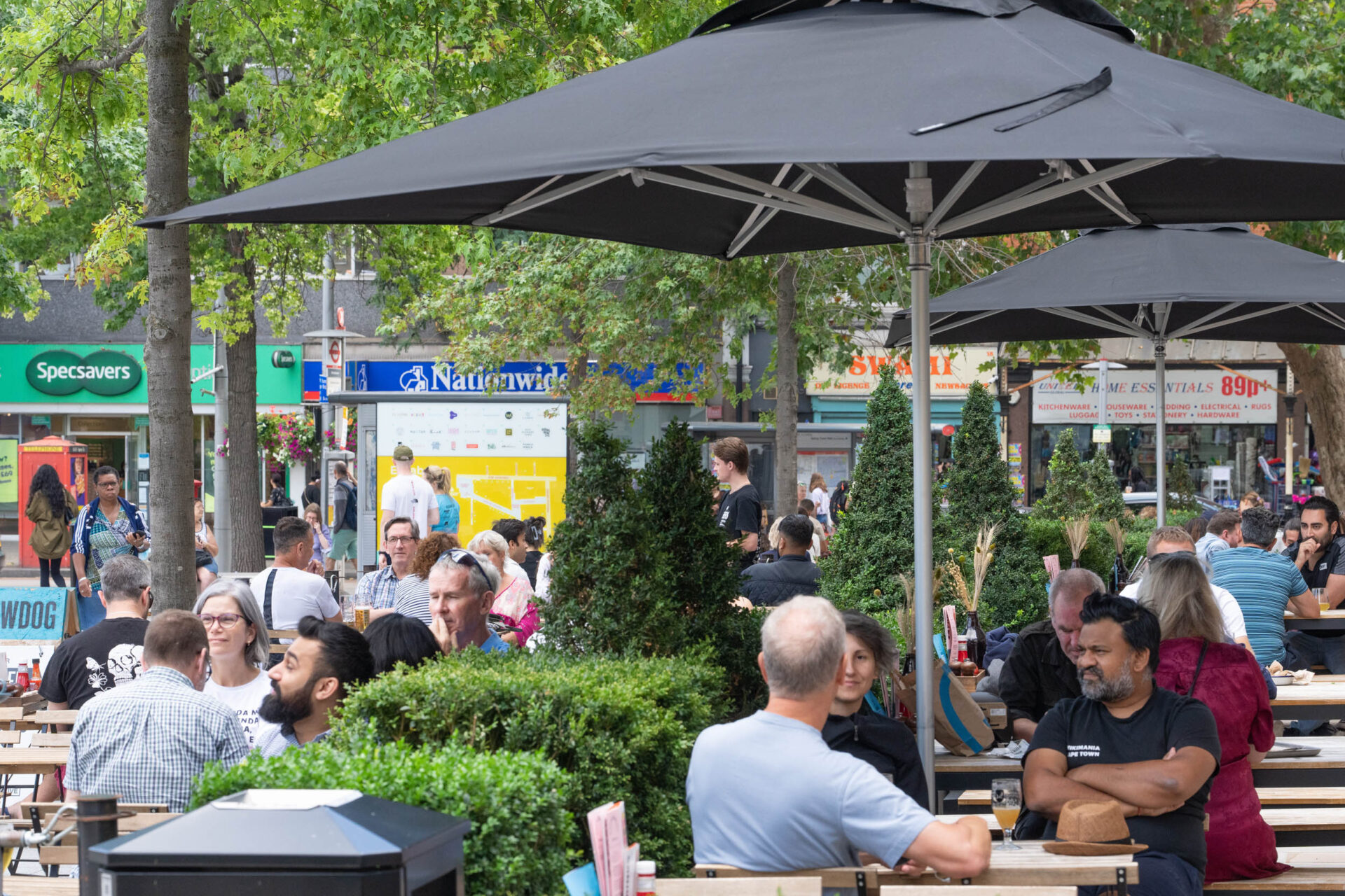 People sitting outside a restaurant, eating and laughing together.