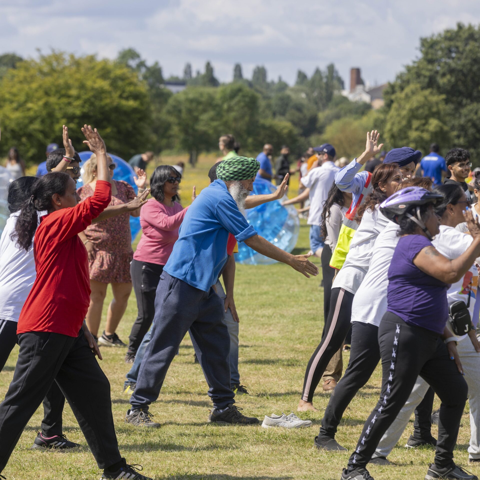 A group of people exercising together in a Park in Perivale Square.