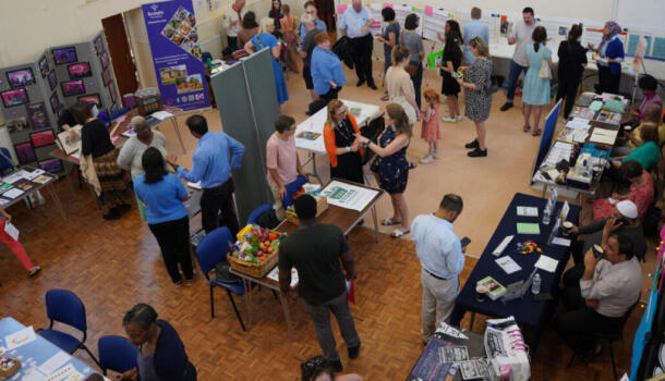 A community hall with lots of people standing around chatting.