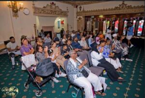 An audience of people sitting and clapping